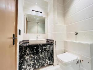 加济阿巴德Hotel IP Swarn Near Anand Vihar Vaishali Ghaziabad的带水槽和马桶的白色浴室