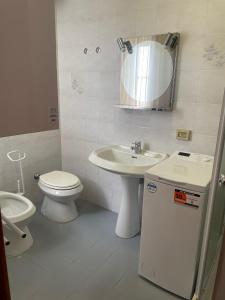 Un baño con lavabo, inodoro y espejo. en Villa Savoia& Villa Trieste, en Grado 24 fotos más