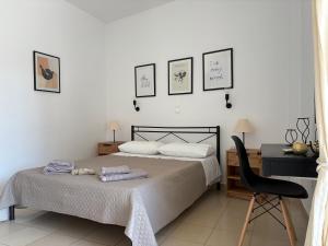 a bedroom with a bed and a desk and a chair at Happiness Apartment 7 in Sidari