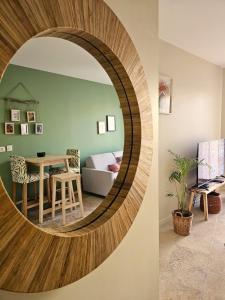 a circular mirror in a living room with a table at Le Loft de Genas Azieu in Genas +119 photos