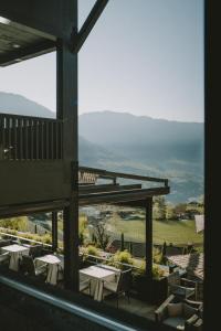 a view from the balcony of a restaurant with tables and chairs at Hotel KÜGLERHOF in Tirolo