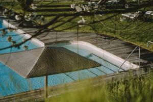 an overhead view of a swimming pool with an umbrella at Hotel KÜGLERHOF in Tirolo