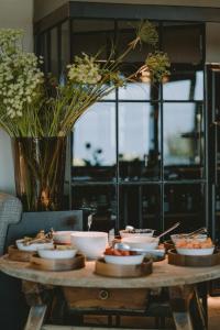 a wooden table with bowls of food on it at Hotel KÜGLERHOF in Tirolo +176 photos