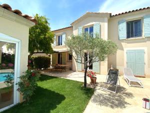 ein Haus mit einem Garten mit einem Baum und einem Stuhl in der Unterkunft Villa avec piscine in La Ciotat
