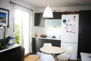 eine Küche mit einem weißen Tisch und einem weißen Kühlschrank in der Unterkunft Villa avec piscine in La Ciotat
