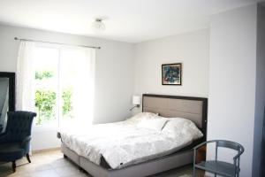 ein Schlafzimmer mit einem Bett, einem Stuhl und einem Fenster in der Unterkunft Villa avec piscine in La Ciotat + 19 Fotos