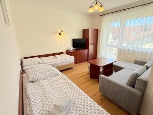 a living room with two beds and a television at Albatros PRZY PLAŻY in Władysławowo