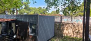 a black house with a wall and a fence at Mobile home Ivan Vodice in Vodice