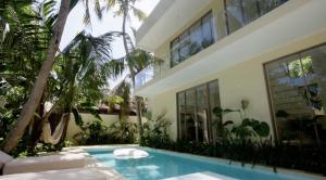 アハンガマにあるVilla Veraのヤシの木とスイミングプールのある家