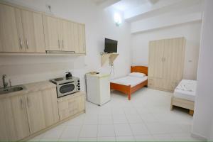 Una pequeña cocina con nevera y microondas. en Apartments Flower, en Sarandë