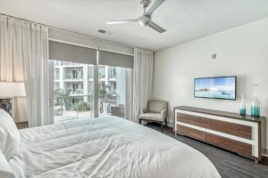 Un dormitorio blanco con una cama y un televisor. en The Pointe Unit 121 by 30A Escapes, en Rosemary Beach