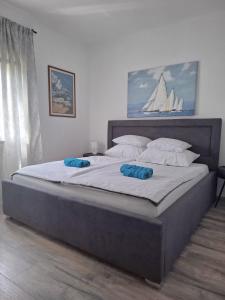 a large bed with two blue pillows on it at Holiday House DA & DO in Pakoštane +47 photos