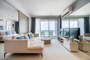 a living room with a couch and a tv at 3BR Seaview - Veranda Pattaya - Luxe in Na Jomtien