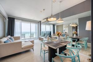 a living room with a table and chairs and a couch at 3BR Seaview - Veranda Pattaya - Luxe in Na Jomtien