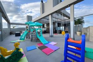 a playground with colorful play equipment on a roof at Apartamentos Elegance 413 in Bombinhas
