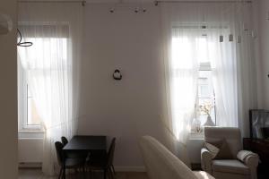 a living room with a table and two windows at Magnolia 1 in Gliwice