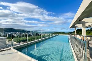 a swimming pool with a view of the ocean at Apartamentos Elegance 413 in Bombinhas