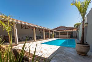 a villa with a swimming pool and a house at Pacheco Festas & Eventos in Barretos