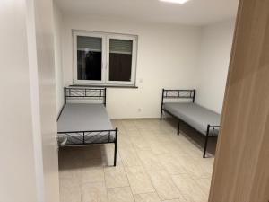 two beds in a room with a window at 3 Zimmer Apartment in Wiesbaden in Wiesbaden +3 photos