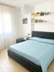 a bedroom with a large bed with a blue comforter at Casa La Marina a Marina di Cecina by Zoom In Earth in Marina di Cecina +13 photos