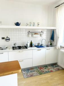 a kitchen with white cabinets and a sink at Casa La Marina a Marina di Cecina by Zoom In Earth in Marina di Cecina
