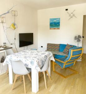 a dining room with a table and chairs and a couch at Casa La Marina a Marina di Cecina by Zoom In Earth in Marina di Cecina