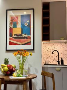 a kitchen with a table with a vase of fruit at Apartament ShipYard Loft Gdańsk by TriApart in Gdańsk