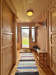a hallway with a rug on the floor and a door at Cottage Yard - cozy Cabin in Geilo