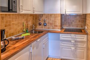 a kitchen with white cabinets and a sink at Ferienwohnungen im Hotel Royal in Timmendorfer Strand +2 photos