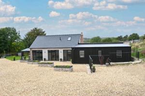 a black and white house with a gravel yard at Bage Mine Barn in Wirksworth