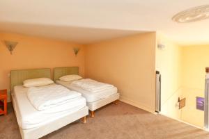 two beds in a room with yellow walls at Appartement piscine et plage 4p 2ét in Le Croisic