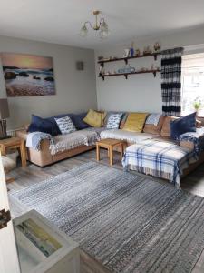 a living room with two couches and a rug at The Beach House Annalong Cosy beachview cottage in Annalong