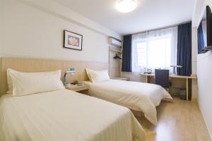 Uma cama ou camas num quarto em Jinjiang Inn - Huzhou Bailemen