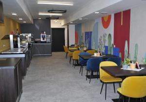 a dining room with tables and yellow chairs at HRADBY hotel a restaurace in Uničov