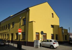 a yellow building with a car parked in front of it at HRADBY hotel a restaurace in Uničov