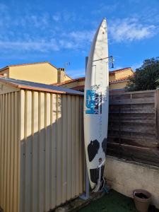 een surfplank staat tegen een hek bij Oacys in Le Barcarès