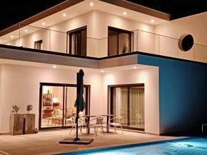 a house with a pool and a table and chairs at Ikigai B&B in Carvalhal