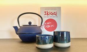 a blue tea kettle and two cups on a table at Ikigai B&B in Carvalhal