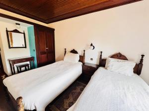 a bedroom with two beds and a mirror at Bica Boa in Monchique