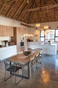 Una cocina grande con una mesa y sillas en una habitación. en Villa Scarabee, en Hoedspruit