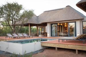 una casa con piscina y patio en Villa Scarabee, en Hoedspruit