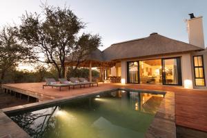una casa con piscina delante de una casa en Villa Scarabee, en Hoedspruit