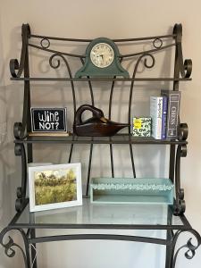 a glass shelf with a clock and books at The Firefly Lodge at Shenandoah in Rileyville