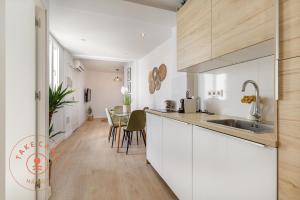 kuchnia z białymi szafkami i jadalnią w obiekcie Cosy apartment in Malaga Centro - TCM w Maladze