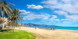 Plaża z grupą ludzi siedzących na piasku w obiekcie Cosy apartment in Malaga Centro - TCM w Maladze