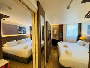 a hotel room with two beds and a bathroom at Best Western Hotelio Montpellier Sud in Montpellier +62 photos