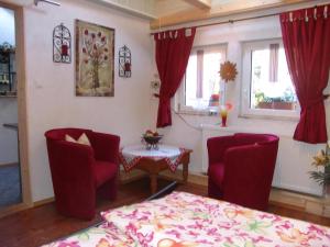 ein Wohnzimmer mit roten Stühlen und einem Tisch in der Unterkunft Wohnung in LübbenauSpreewald mit Garten, Terrasse und Grill in Lübbenau