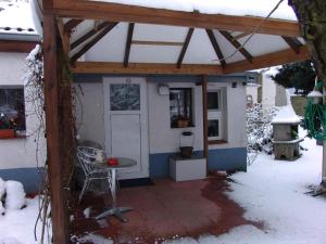 ein Schuppen mit einer Tür und einem Tisch im Schnee in der Unterkunft Wohnung in LübbenauSpreewald mit Garten, Terrasse und Grill in Lübbenau + 32 Fotos