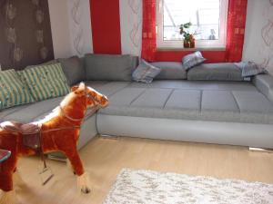 ein Hund steht neben einer Couch im Wohnzimmer in der Unterkunft Appartement in LübbenauSpreewald mit Garten und Grill in Lübbenau