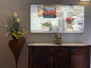 a painting of flowers on top of a wooden cabinet at Hotel Erika in Arzl im Pitztal